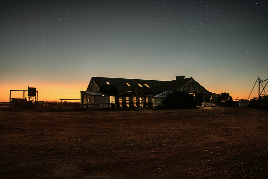 Image of warehouse, with sunset in the background